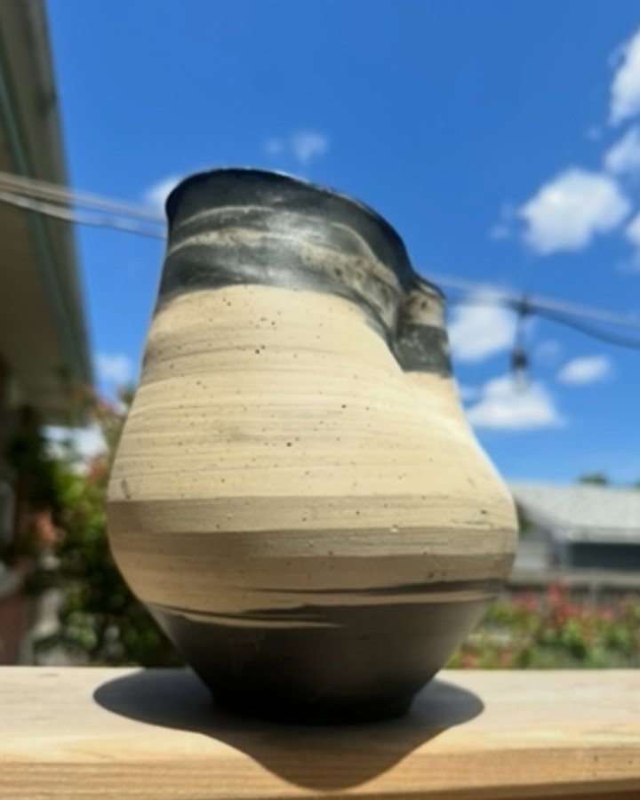 A hand-thrown stoneware vase Patricia made, charcoal glaze fading into bare clay